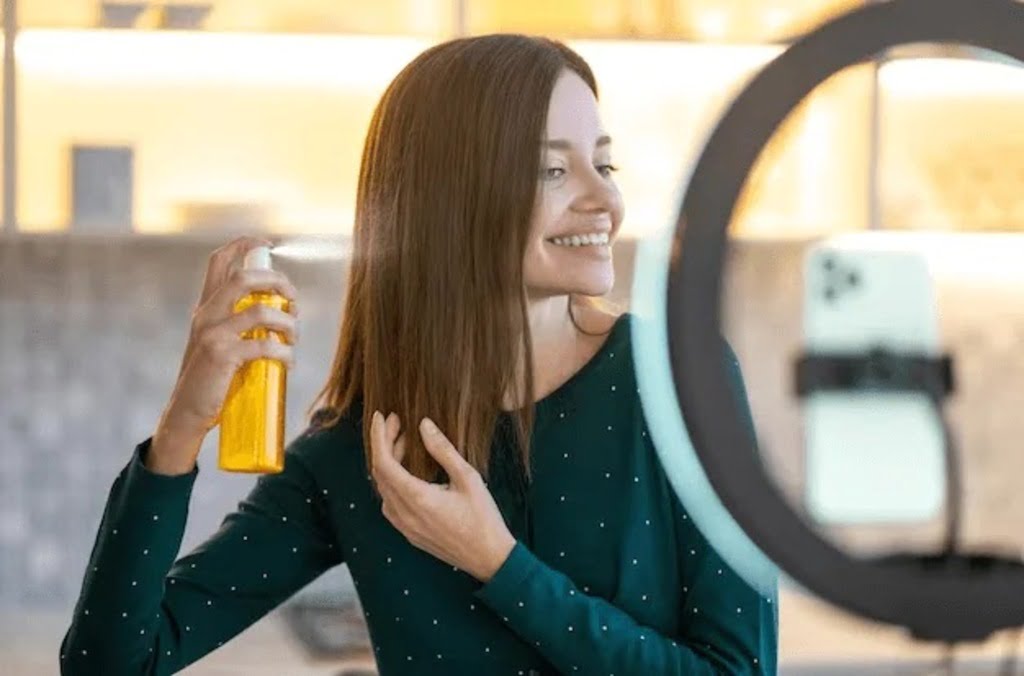 woman spraying oil on hair